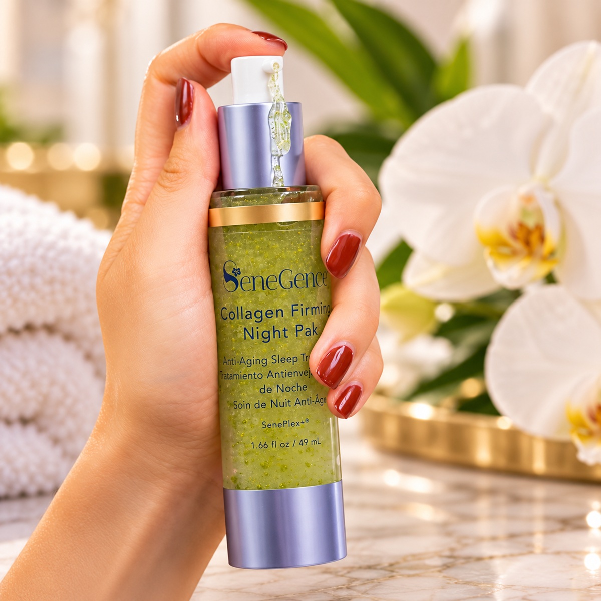 SeneGence Collagen Firming Night Pak bottle held in a hand with burgundy nails, dispensing green botanical gel